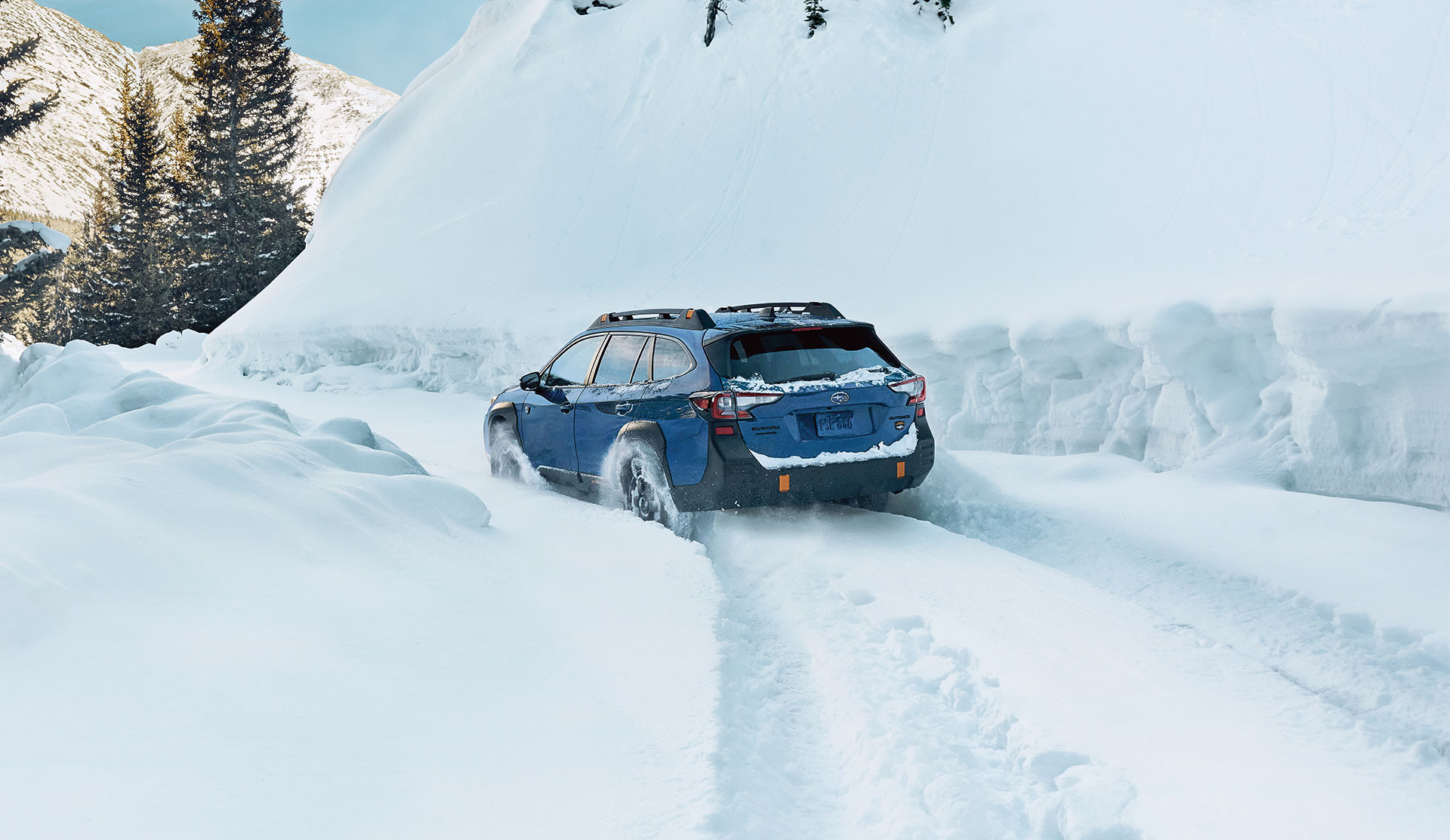 2025 Subaru Outback Wilderness Rear shot of 2025 Outback Wilderness driving in deep snow